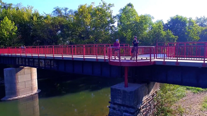 Exterior Two bicyclists take a picture from a bridge on the Monon Trail