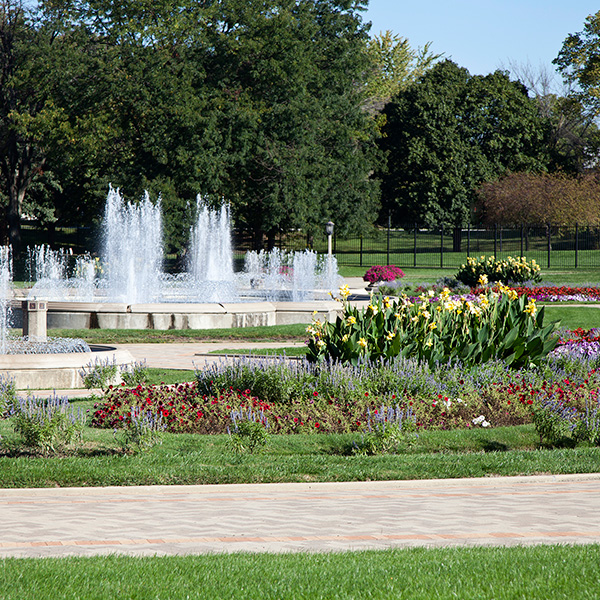 Park garden with walking path, flowers, and fountains