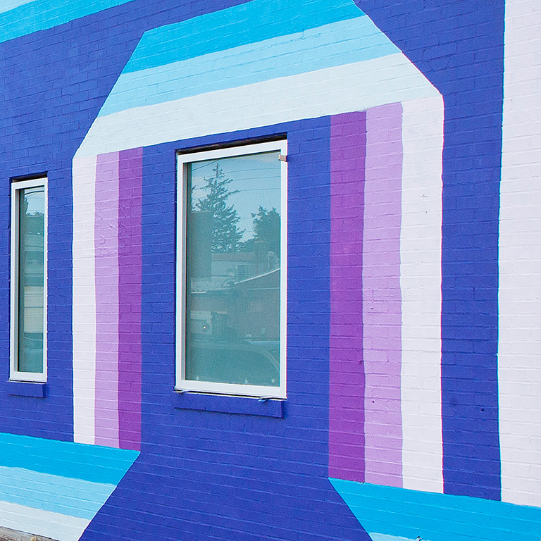 Brick building with purple and blue mural painting