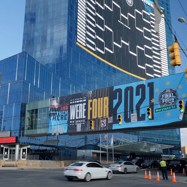 Exterior wide shot of 2021 March Madness signage on skywalk and Bracket signage on JW Marriott in the background