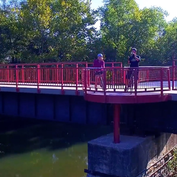 Two bicyclists take a picture from a bridge on the Monon Trail