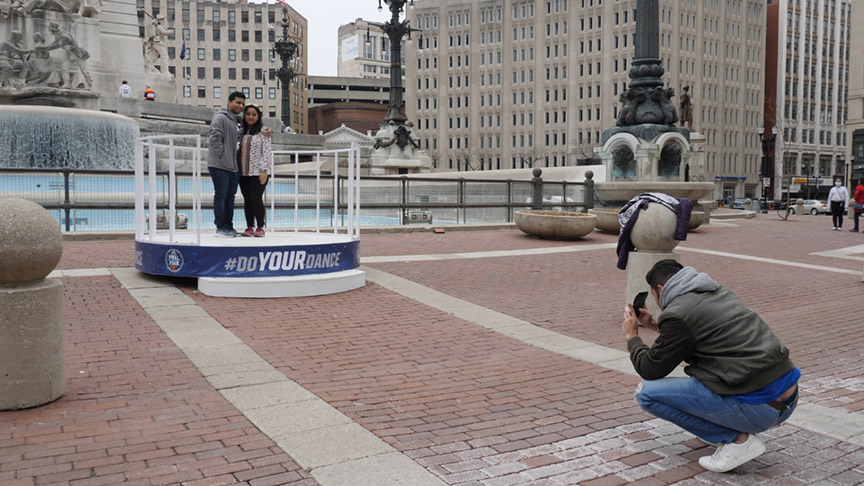 A couple has their picture taken on Monument Circle