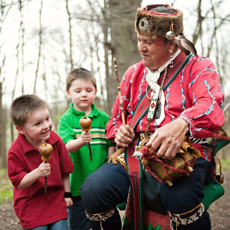 Two young boys interact with a Lenape Indian enactor at Conner Prairie