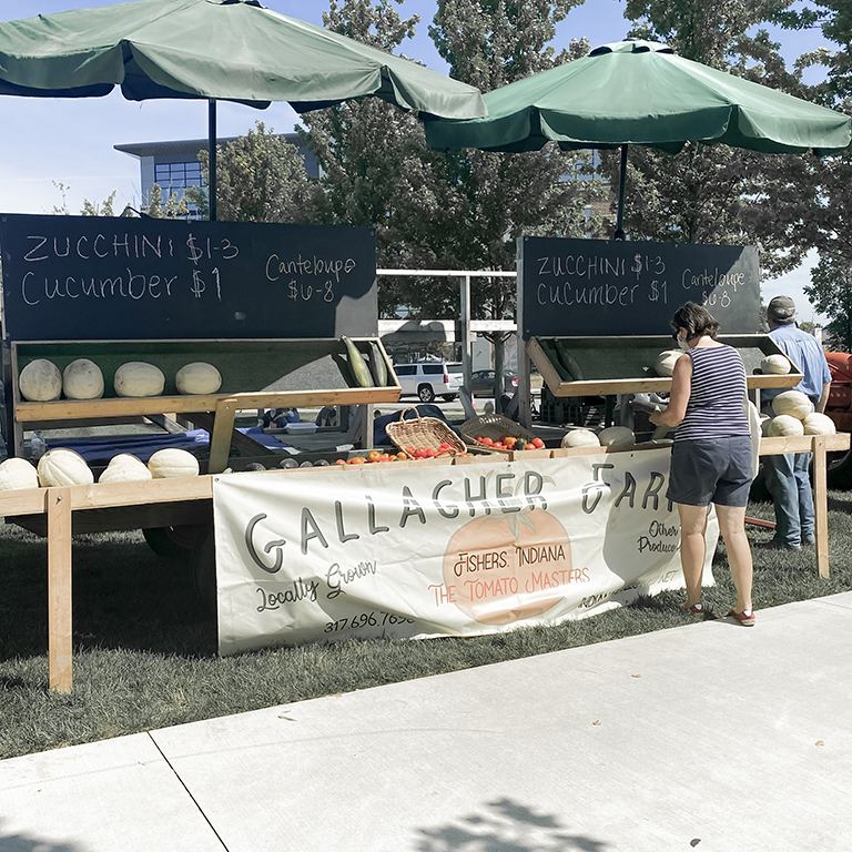 A woman shops at the Gallagher Farm stand at the Fishers Farmers Market