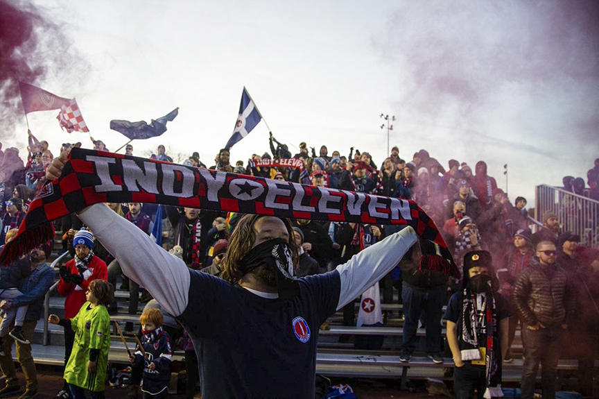 Fan holding up Indy Eleven Banner in front of other Indy Eleven fans