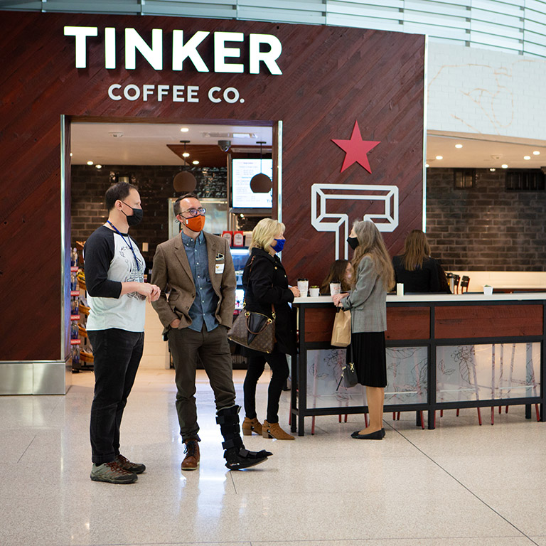 Persons gathered at Tinker Coffee Company in the Indianapolis Airport terminal