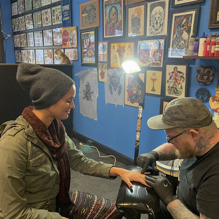 Tattoo artist prepares a customer for a new tattoo.