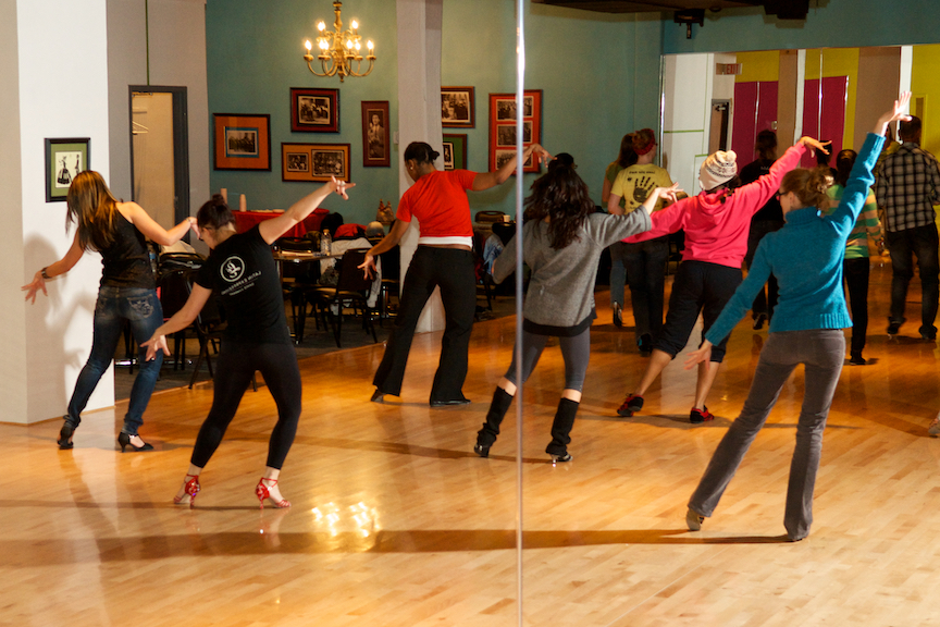 People dancing in front of a mirror in a Latin dance class