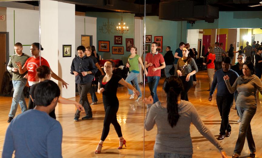 People dance in front of a mirror for a Latin dance class