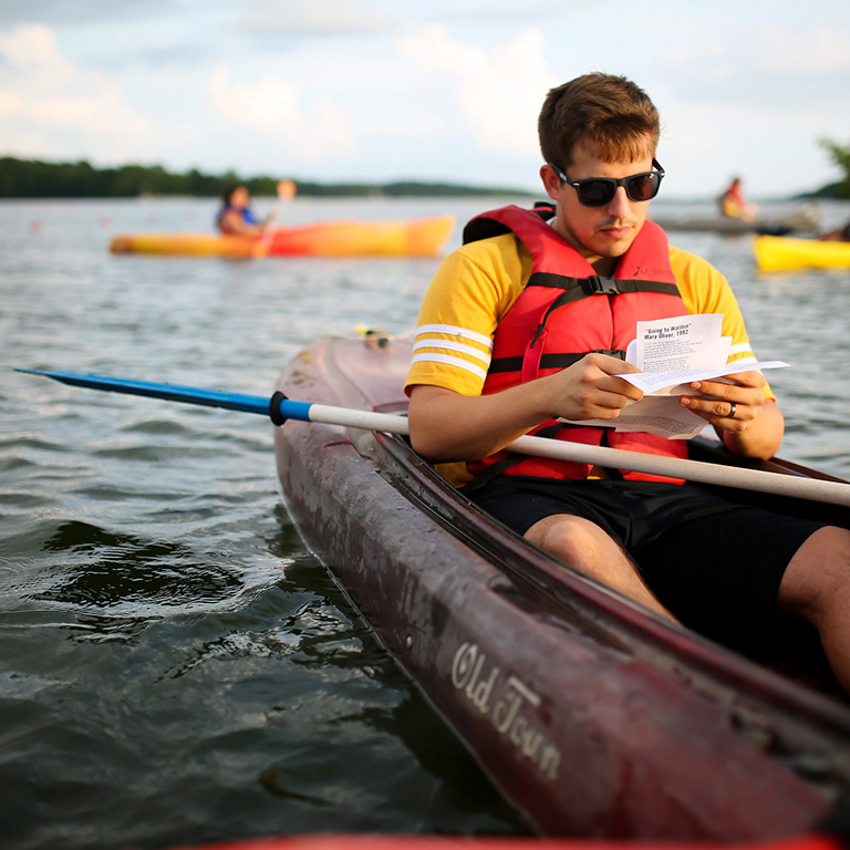 Person sitting in a kayak and reading