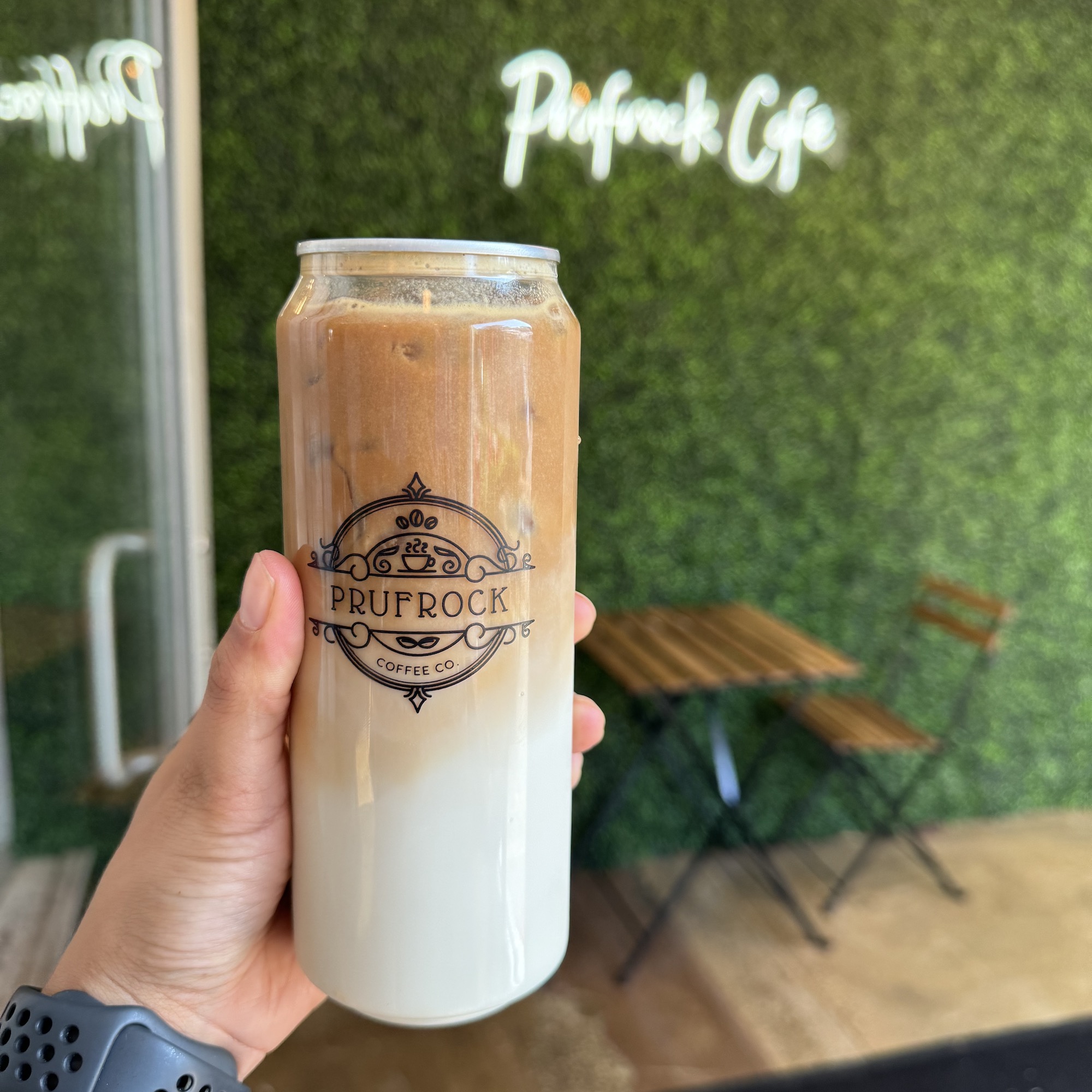Prufrock Coffee Holding up a can at Prufrock Coffee