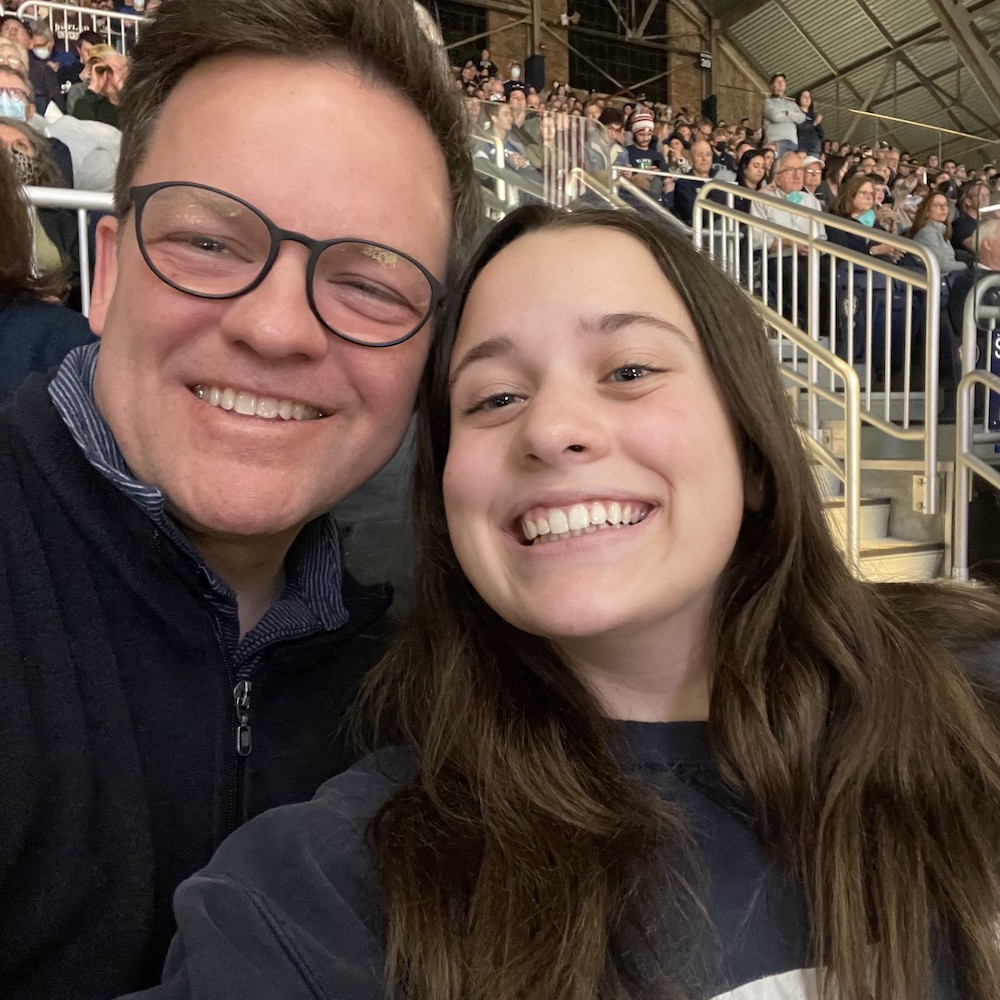 Young woman and her dad smiling in the stands at Hinkle Fieldhouse