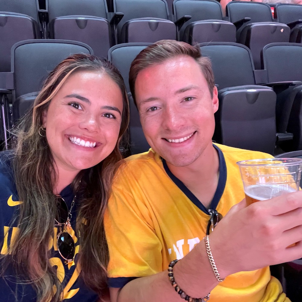 A young man and woman taking a selfie from stadium stands