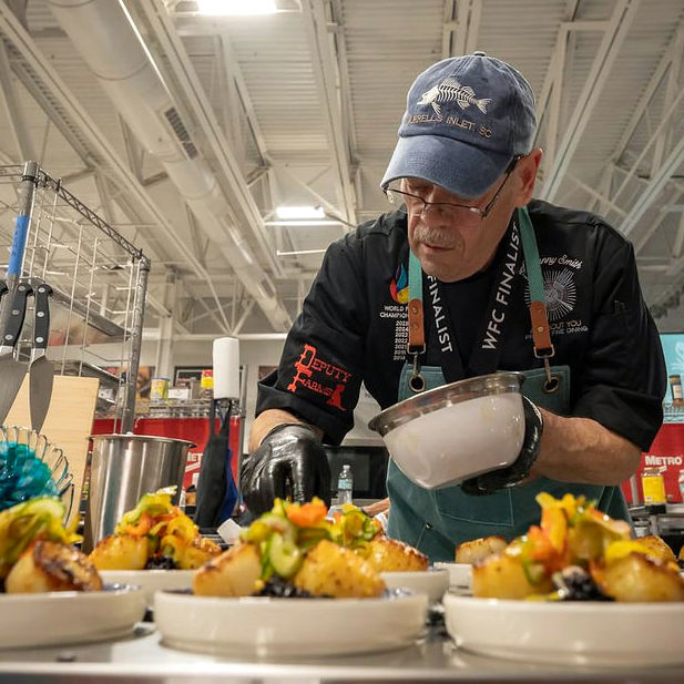 Chef Putting the Finishing Touch on Food at World Food Championships Chef Putting the Finishing Touch on Food at World Food Championships